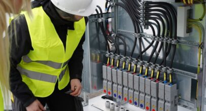 Mitarbeiter der TRICERA energy vor Schaltungen eines Batteriespeichers