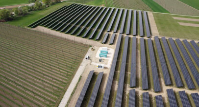Batteriespeicher der TRICERA energy umrahmt von einer riesigen PV-Anlage