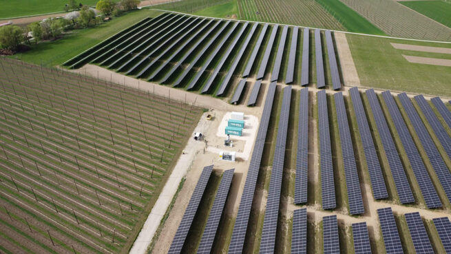 Magazyn energii firmy TRICERA energy otoczony ogromną instalacją fotowoltaiczną