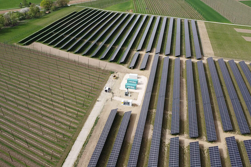 Batteriespeicher der TRICERA energy umrahmt von einer riesigen PV-Anlage