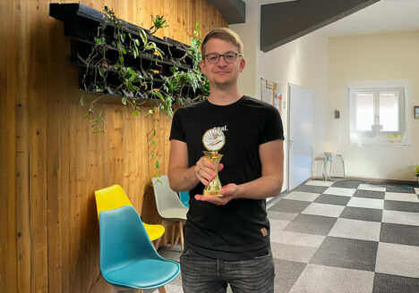 Philipp Berger, Referent für Marketing und PR bei der TRICERA energy, mit dem Siegerpokal des Billard-Turniers in der Hand