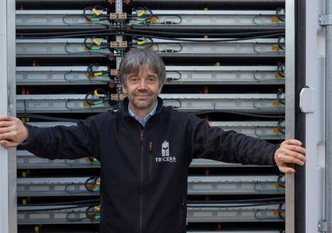 Tim Müller, Geschäftsführer der TRICERA energy, vor geöffnetem Batteriespeicher