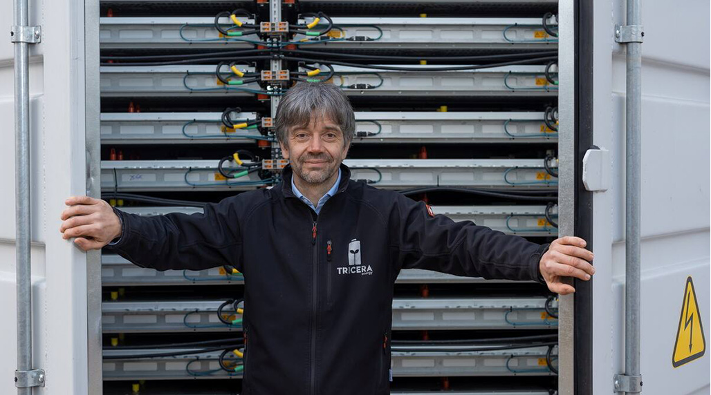Tim Müller, Geschäftsführer der TRICERA energy, vor geöffnetem Batteriespeicher